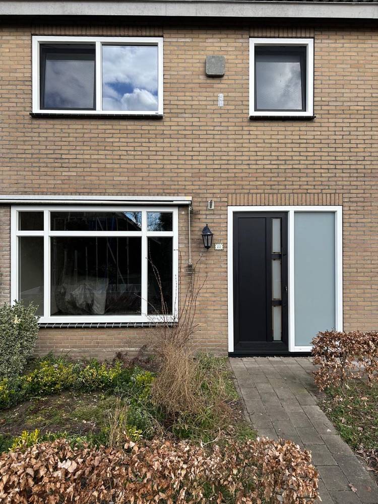 Vernieuwde voorgevel met kunststof kozijnen en moderne zwarte voordeur in Tilburg